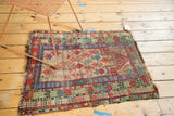 Geometric prayer design, prominent knot heads, and tattered ends on a vintage Caucasian rug.