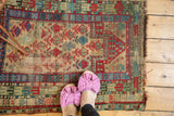 Hand knotted vintage Caucasian rug pile showing geometric germinating flowers and visible even wear.