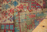 Geometric stylized flowers, tattered ends, and exposed foundation of vintage Caucasian rug.