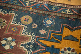 Vintage Russian rug detail with indigo blue field, saffron yellow geometry, and scattered floral patterns.