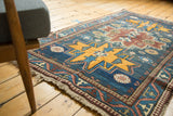 Vintage Russian runner's geometric border and secured fringe in indigo, saffron, and copper tones.