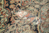 Close-up of a vintage Dargezine rug showing heavy wear, restrung foundation, and simplified floral outlines.