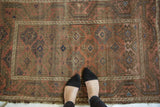 Hooked gul motifs on abrashed blush and mauve field of an Antique Belouch rug.