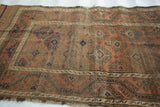 Abrashed blush and mauve field reveals repeating hooked gul motifs and channel border of this antique Belouch.
