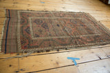 Hand-knotted antique Belouch rug showing fringed end with hard tatter and striped kilim.