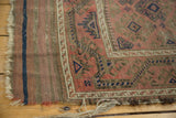 Geometric border and field of an antique Belouch rug with tattered fringe.