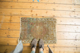 Corner of vintage Oushak rug showing hexagonal spandrel, hook-and-latch border, and worn fringe.