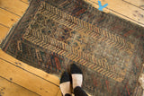 Antique Belouch rug displaying natural camel triple column design with foundation wear.