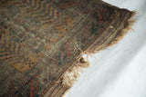 Hard tatter and exposed foundation weave at the edge of this antique Belouch rug.