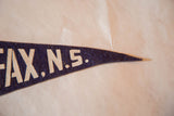 Detail of cream 'AX, N.S.' lettering on vintage blue felt pennant's pointed end.