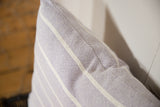 Lavender hand-woven pillow featuring textured fabric and distinct white stripes.