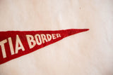 Textured red felt vintage pennant with white 'TIA BORDER' lettering.