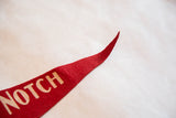 Vintage red felt pennant tip with textured surface and visible NOTCH lettering.