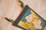 Detail of vintage Mt. Agassiz felt pennant showing blue binding, green tie, and gold-picking hand.