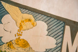 Vintage Mt. Agassiz flag close-up: hand dropping yellow gold, blue stripes, partial 'M'.