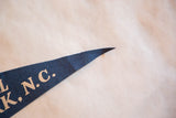 Pointed end of vintage dark blue felt pennant with partial light 'K, N.C.' lettering.