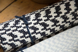 Organic cotton rag rug showing navy-black and off-white subtle chevron pattern.