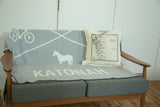 Katonah map pillow styled on a mid-century modern sofa with a coordinating throw blanket.
