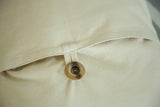 Marbled button and loop detail of the envelope closure on a cotton throw pillow.