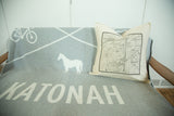 Antique Katonah map pillow styled with a grey and white themed throw blanket.