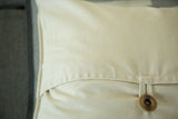 Cotton pillow back with a brown buttoned envelope closure.