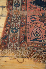 Tattered fringe and worn geometric border on an antique Malayer rug.