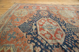 Rectilinear floral blossoms and tendrils on an antique Caucasian Soumac rug with madder red, navy blue.