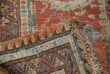 Soumac carpet's madder red geometric design, hand woven texture, and fringed edge.