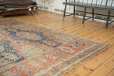 Antique Caucasian Soumac rug end with geometric madder red and navy blue patterns.