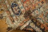 Antique Caucasian Soumac rug corner revealing worn pile, visible foundation, and textured selvage.