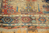 Lower border of antique Soumac rug, intricate geometric motifs in red, blue, with tattered fringe.
