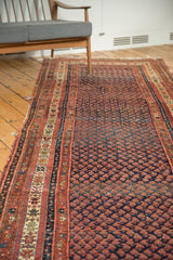 Indigo blue boteh pattern with madder red accents on an antique Kurdish Malayer runner, showing aged selvage.