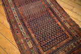 Antique Kurdish Malayer runner's detailed indigo field, repeating boteh pattern, and madder red borders.