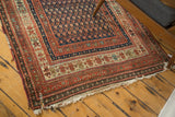 Antique Kurdish Malayer rug corner with intricate madder root red, indigo borders, and localized tatter.