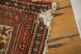 Localized tatter on off-white fringe and dark side cord selvage of antique Malayer runner.
