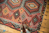 Antique Kilim detail: Cherry red and faded blue diamond and hook motifs with aged texture.