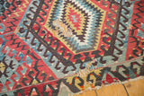 Antique Turkish Kilim with a large hole in its tattered geometric red, blue, and gold field.