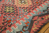 Aged Turkish Kilim surface with geometric hook and latch motifs in cherry red and sky blue.