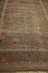 Wear and exposed foundation on antique Belouch rug, showing muted madder red and brown hues.