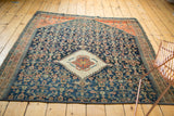 Antique Persian rug fragment corner with navy Herati design, terra cotta abrashes, and ivory pomegranate motif.