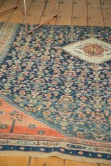 Antique Persian rug detail: navy Herati field, terra cotta spandrel, central medallion.