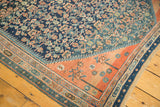 Antique Persian rug corner shows intricate navy Herati field, fantastic terra cotta abrashes, and patterned borders.