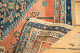 Antique Persian rug fragment's machine-bound edge and intricate navy, terracotta border.