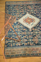 Fine hand-knotted Persian rug fragment detail: ivory pomegranate medallion on a navy Herati field.
