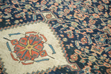 Antique Persian fragment's navy Herati field meets ivory spandrel with pomegranate motif and abrashes.