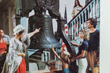 Colonial woman pointing at Liberty Bell, child reaching out in vintage Kodak print.