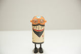 Vintage dentist Popsie toy character with orange head, round glasses, and wide grin.
