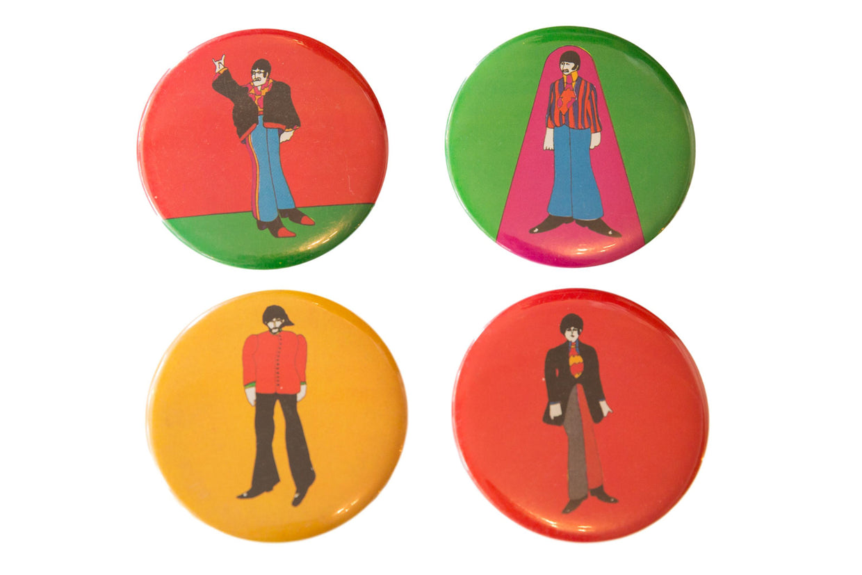 Collectible set of four Yellow Submarine Beatles pins, bright character art on red, green, yellow.