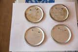 Reverse side of four Yellow Submarine Beatles pins showing rust and fasteners.