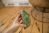 Vintage watermelon piggy bank with chipped green paint, money slot, and wire loop.